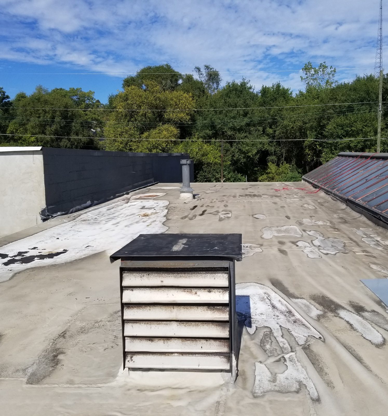 An aging, patched membrane roof before renewal