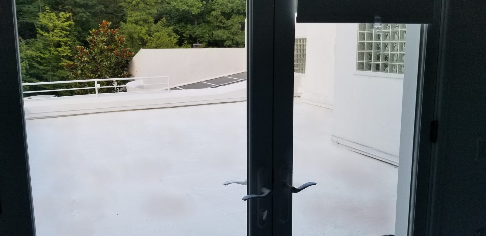 A finished rooftop terrace viewed through French doors